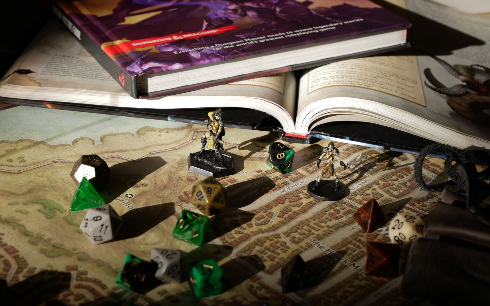 Dadi poliedrici, miniature e mappa su un tavolo: una sessione di gioco di ruolo