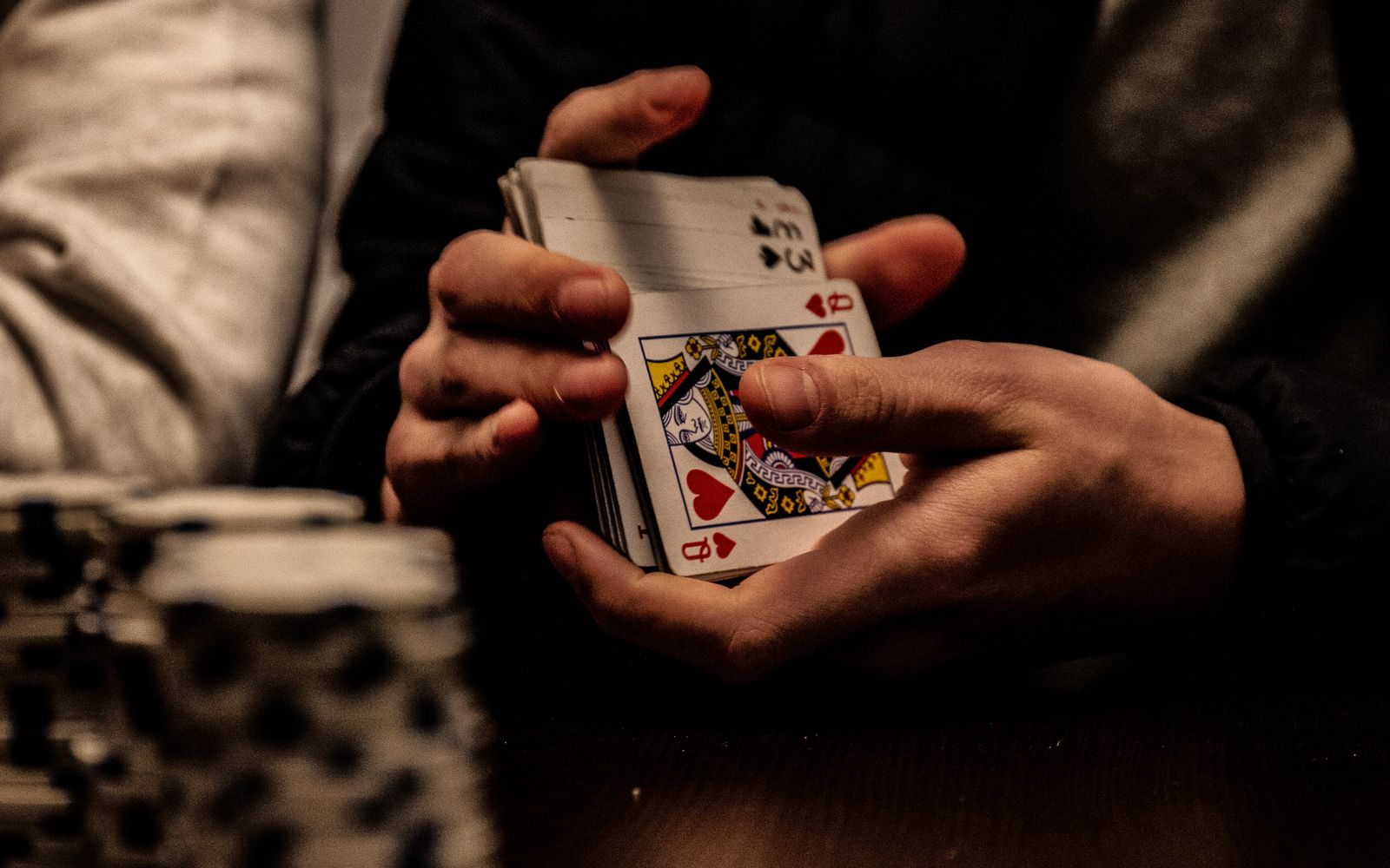 Mani che tengono le carte da gioco durante una partita: i migliori giochi di carte in due