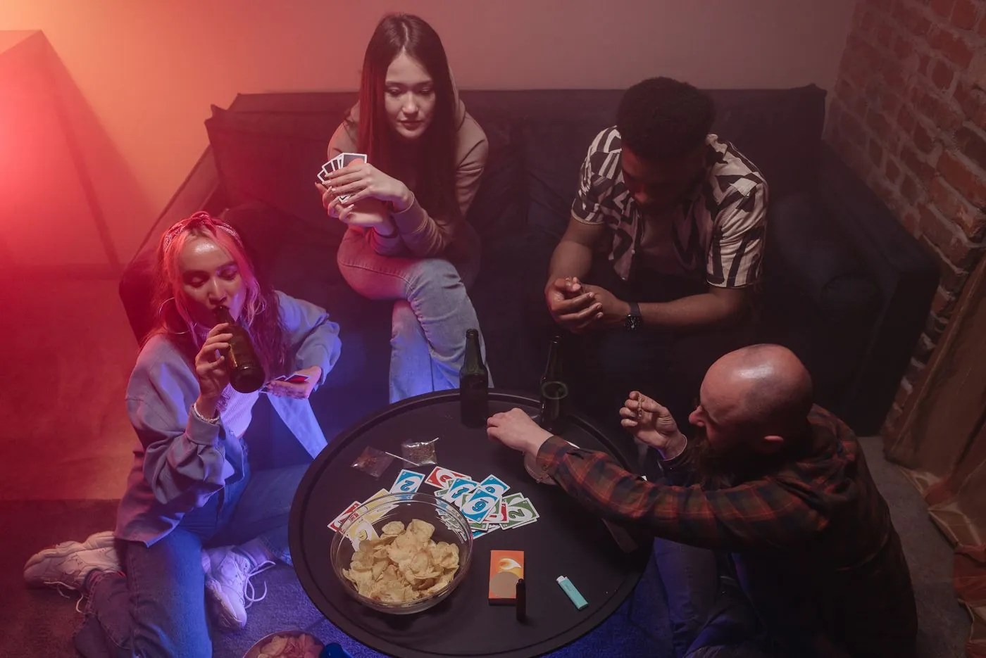 Gruppo di amici adulti che ride giocando a carte durante una serata in casa